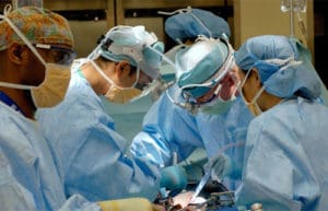 A group of surgeons performing surgery on someone in the hospital.