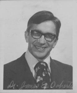 A man in suit and tie smiling for the camera.