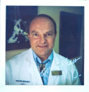 A man in white lab coat and blue tie.