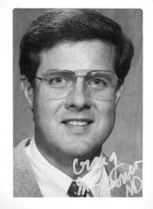 A man with glasses and a jacket on.