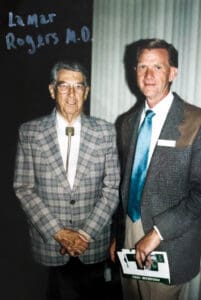 Two men in suits standing next to each other.