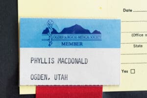 A name tag hanging on the side of a building.