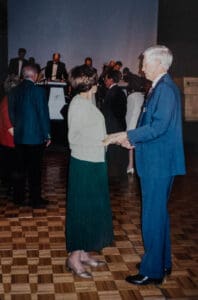 A man and woman dancing in front of other people.