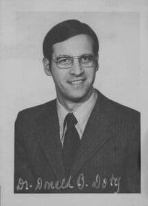 A man in suit and tie smiling for the camera.