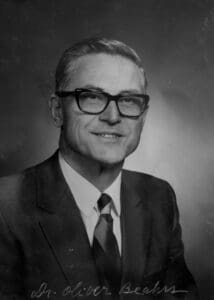 A man in suit and tie wearing glasses.