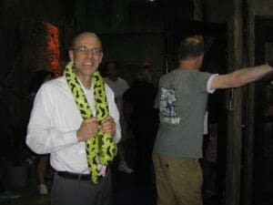 A man with a green and black scarf around his neck.